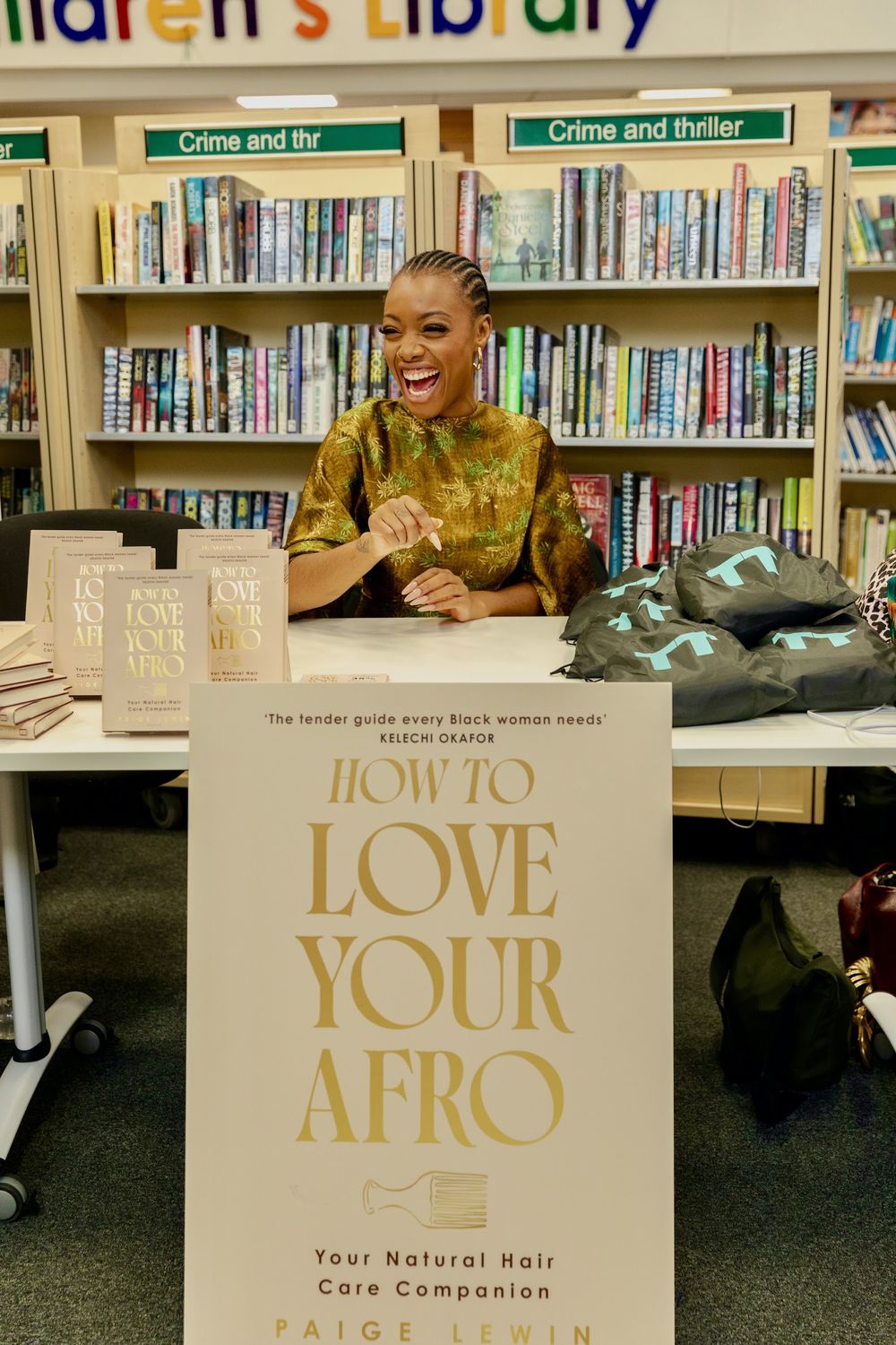 Paige at a library event beside a How to Love Your Afro display